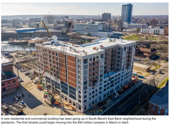 Aerial drone photo of the 300 East mixed use building with multiple cranes working the job site.